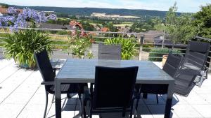 - une table et des chaises sur une terrasse avec vue dans l'établissement FEWO Zum Golfplatz, à Lügde