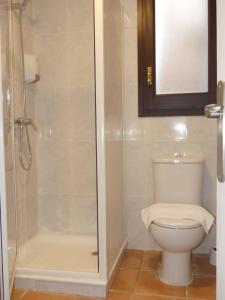 a bathroom with a toilet and a glass shower at APT 2 Acollidor al Centre històric de Vic APTGARBI in Vic