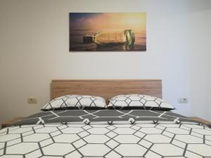 a bed with two pillows and a picture on the wall at Apartman Ana in Porat