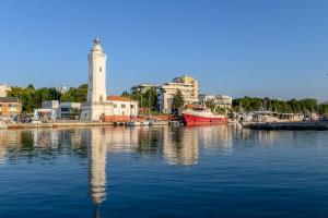 a harbor with a lighthouse and boats in the water at Hotel St Gregory Park in Rimini