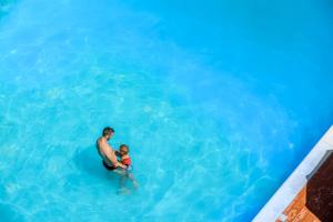 a man and a child in the water at a swimming pool at Hotel St Gregory Park in Rimini