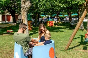a family sitting in a park with a dog at Hotel St Gregory Park in Rimini