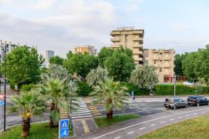 a street with palm trees and a building at Hotel St Gregory Park in Rimini