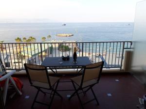 einen Tisch und Stühle auf einem Balkon mit Meerblick in der Unterkunft Antibes: A nest perched on the sea! in Antibes