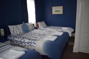 a bed room with a blue and white bedspread at Gatwick Castle B&B in Horley