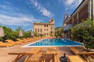 ein Hotel mit einem Pool mit Stühlen und einem Gebäude in der Unterkunft Apart & Spa Beganovic in Dobra Voda