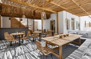 a dining room with a wooden table and chairs at Arco Solium Suites in Adamantas