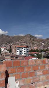 a brick wall with a city in the background at Kantu Progreso Inn in Cusco