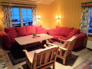 a living room with a red couch and a table at Torsetlia Cottages and Apartments in Uvdal