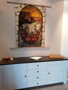 Cette chambre dispose d'une table et d'une peinture murale. dans l'établissement Apartman Luna, à Šibenik