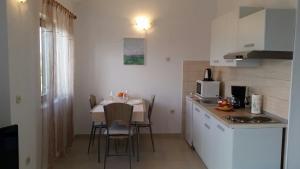 a small kitchen with a small table and a small kitchen with a kitchen at Apartman Ivanica in Jezera
