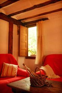 ein Wohnzimmer mit einer Couch und einem Tisch und einem Fenster in der Unterkunft Casa rural LA LAGUNA in Laguna del Marquesado