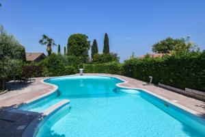 una piscina con agua azul y árboles en Casa Linda, en Ronchi