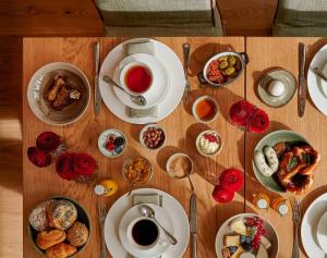 a wooden table topped with plates and bowls of food at Parkhotel Rothof in Munich +83 photos