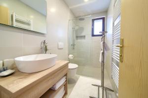 a white bathroom with a sink and a toilet at Apartments Loncar in Krk