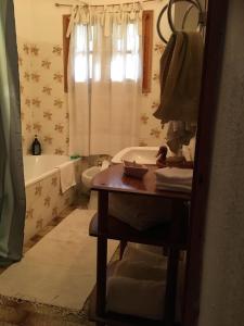 a bathroom with a table and a tub and a sink at THE COUNTRY HOUSE KOUTSOUPIA in Kókkinon Nerón