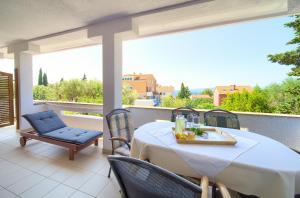una mesa y sillas en un balcón con vistas en Apartments Loncar en Krk
