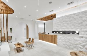 a lobby with white walls and chairs and a counter at Arco Solium Suites in Adamantas