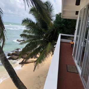 a balcony of a house with a view of the beach at La Veranda Di Serena in Unawatuna