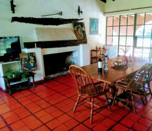 een eetkamer met een tafel en stoelen en een open haard bij Quinta en Pilar in Del Viso