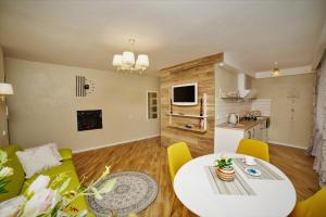 a living room with a white table and yellow chairs at TIP TOP in Šiauliai