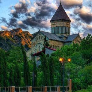 un edificio con una torre en la cima de una colina en Guest House Sveti, en Mtskheta