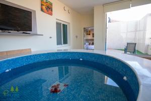 a swimming pool in a house with a blue tiled floor at Pinetree Suites Hail in Hail