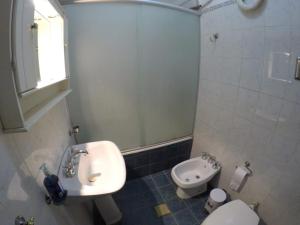 ein kleines Bad mit einem Waschbecken und einem WC in der Unterkunft Casa, hogar equipado para el viajero y su familia. in Cordoba