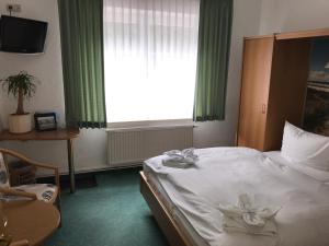 a hotel room with a bed and a window at Pension Am Strand in Juliusruh