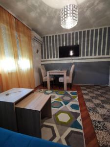 a living room with a table and a tv at Apartment I&M Capljina in Čapljina