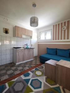 uma sala de estar com um sofá azul e uma cozinha em Apartment I&M Capljina em Capljina