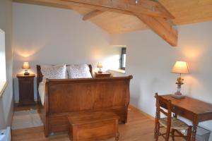 a bedroom with a bed and a desk and a piano at Gîte de Dargilan in Meyrueis