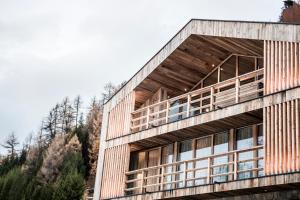 a timber clad building with trees in the background at Chalet Ourtls Pärg in Solda