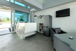 a living room with a large window and a tv at Barocco Wave Hotel in Skala Potamias