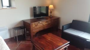 a living room with a tv on a wooden table at Gîte de Dargilan in Meyrueis