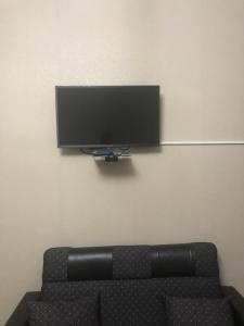 a black couch with a flat screen tv on a wall at SHAKO's Apartments in Tbilisi City