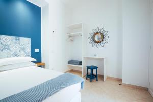 a bedroom with a bed and a mirror on the wall at Chez Lia - Private garden and tub, sea view close to Villa Eva and Cimbrone, Ravello in Ravello