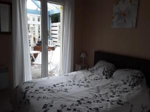 a bedroom with a bed and a window with a view at Chambre Privée Chez l'Habitant in Capbreton