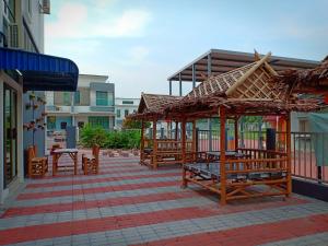 a patio with wooden benches and a pavilion at Kuala Selangor Botanic 4R3B Homestay 15pax in Kuala Selangor