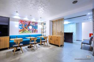 a waiting room with tables and a painting on the wall at Senso Suites in Nea Peramos