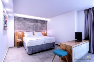 a hotel room with a bed and a television at Senso Suites in Nea Peramos