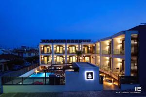 a large building with a swimming pool at night at Senso Suites in Nea Peramos