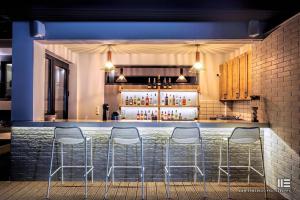 a bar with four stools in front of it at Senso Suites in Néa Péramos