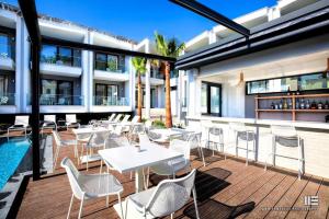 a patio with tables and chairs on a building at Senso Suites in Nea Peramos