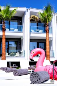 a pink inflatable flamingo statue in front of a building at Senso Suites in Nea Peramos