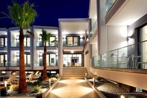 a building with palm trees in front of it at Senso Suites in Nea Peramos