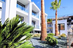 a building with palm trees in front of it at Senso Suites in Nea Peramos