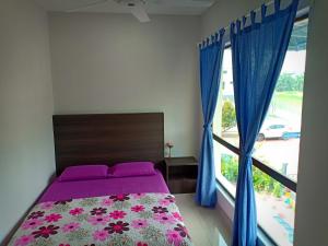 a bedroom with a bed with purple sheets and a window at Kuala Selangor Botanic 4R3B Homestay 15pax in Kuala Selangor