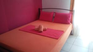 Una cama pequeña con un osito de peluche en una toalla rosa en AGATHA appartments PALIOURIA, en Kokkino Nero