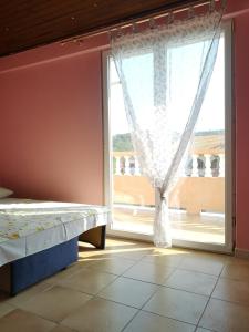 a bedroom with a bed and a large window at Apartments Sandra in Lopar